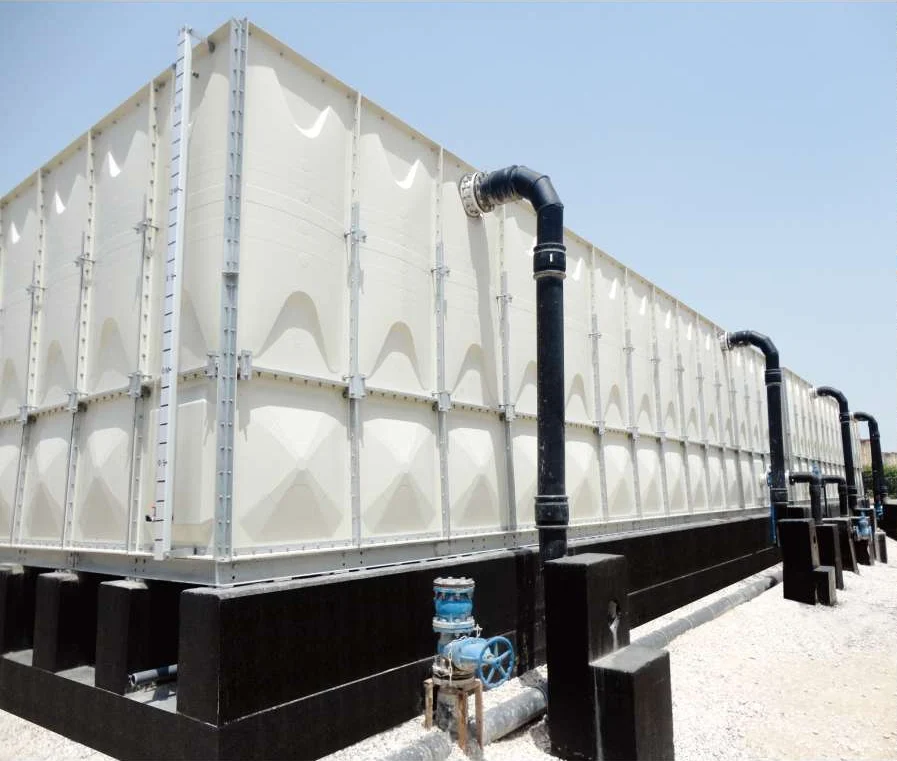 Large hot pressed GRP sectional panel water tank on concrete plinths with black pipework